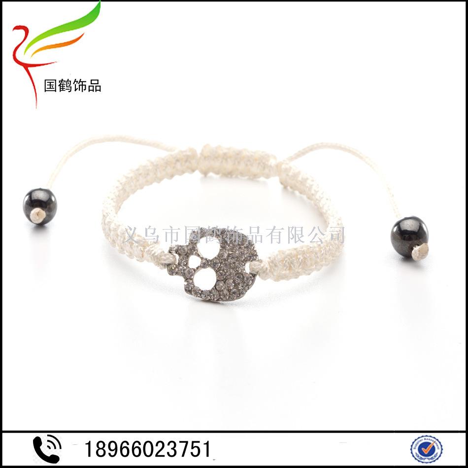 Diamond-encrusted skull with hand woven men's bracelet.